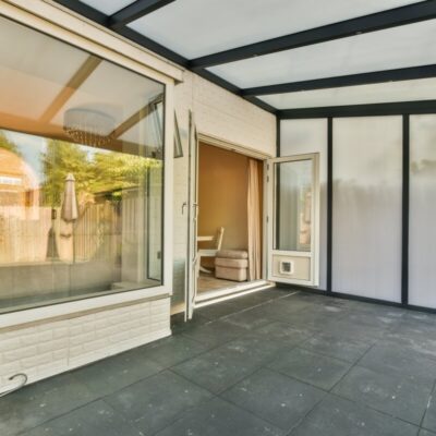 Ein moderner Innenhof mit großen Fenstern und sichtbaren Holzterrassenlamellen.