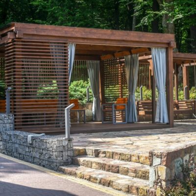 Ein überdachter Pavillon im Freien mit Holzterrassenlamellen.