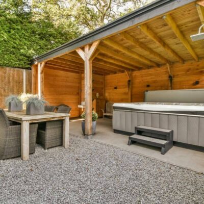 Eine gemütliche Terrasse mit Whirlpool, Essbereich und bewegliche Holzlamellen für Pergolen.