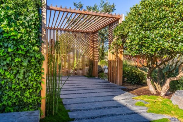 Ein moderner Gartenpavillon mit einem System aus beweglichen Holzlamellen bietet eine harmonische Verbindung zur Natur.